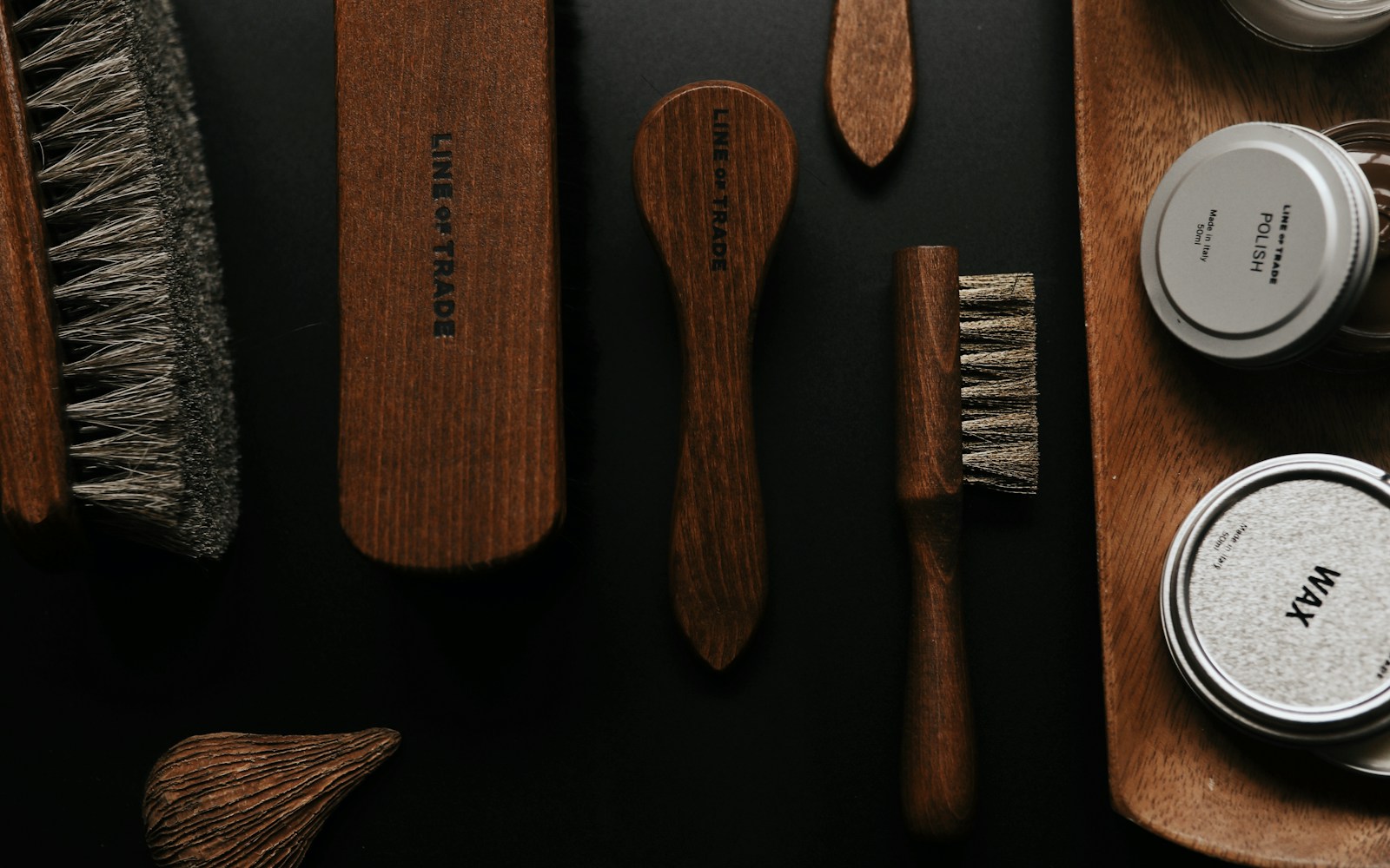 Cepillos y productos de cuidado para barbería sobre superficie oscura