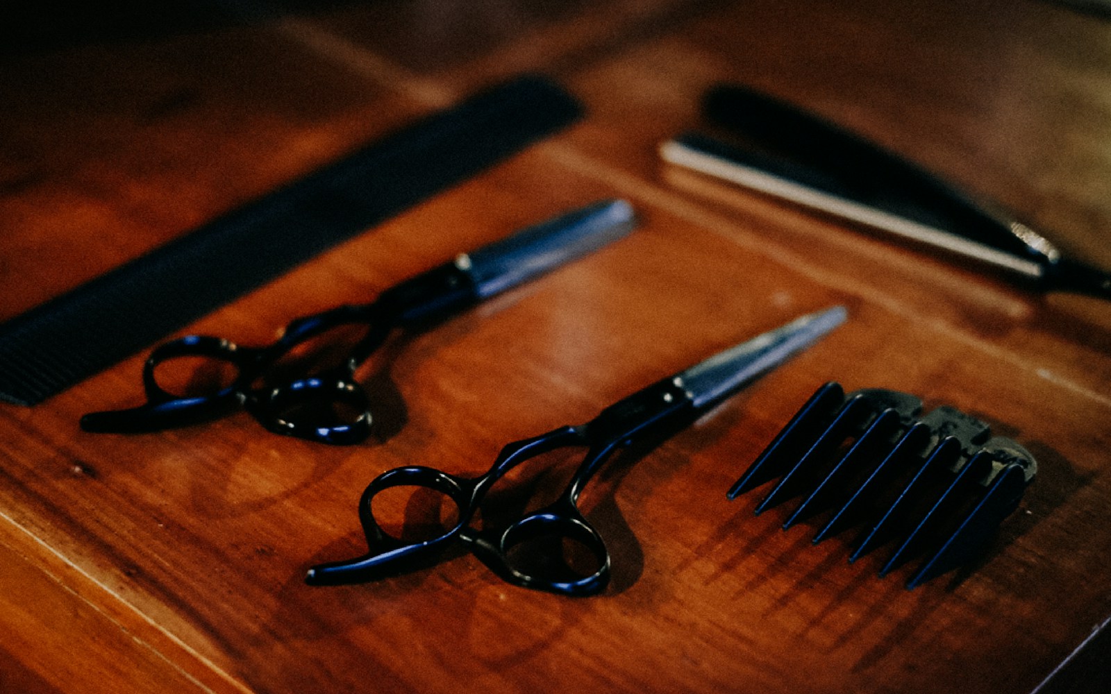 Tijeras profesionales para barbería sobre superficie de madera